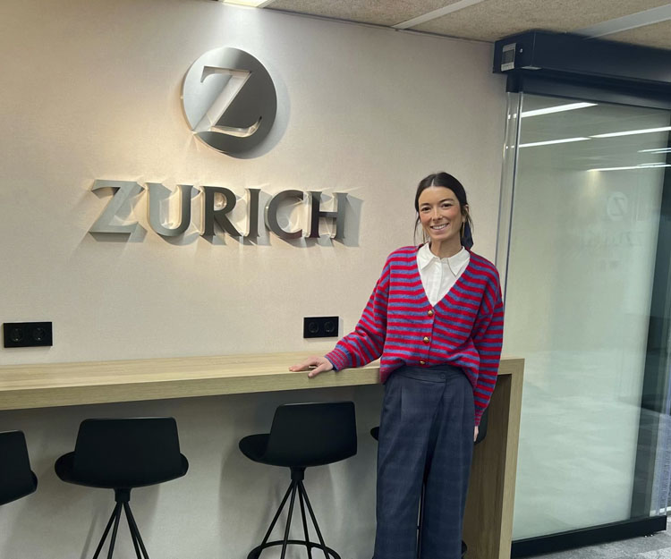 colaboradora Zurich apoyada en una mesa